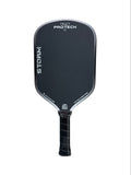 A black pickleball paddle with a textured grip handle, featuring the PROTECH brand name and STORM model printed in white on the paddle face, set against a plain white background.